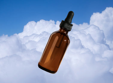 cannabis tincture bottle on cloud background